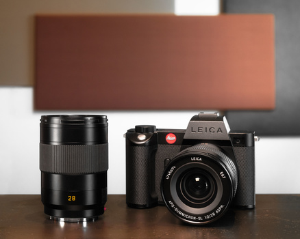 Leica APO-Summicron-SL 28 f/2 ASPH lens and Leica camera body on a table